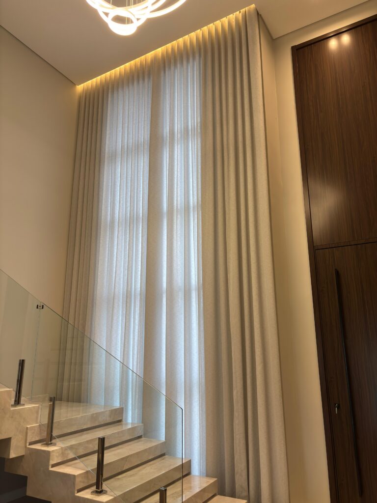 Sala de estar com cortina de linho em pé-direito alto — Rioma Decor, Florianópolis